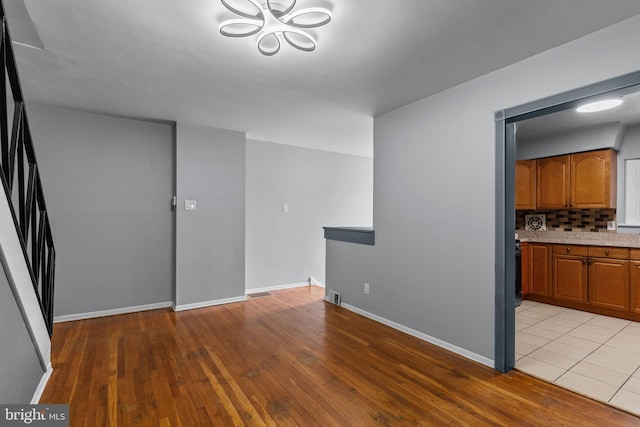 3583 Nottingham Ln, Philadelphia, PA 19114 - unfurnished dining area with light wood-style floors, baseboards, a chandelier, and stairway