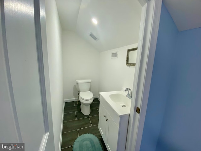 bathroom featuring vaulted ceiling, vanity, tile patterned floors, toilet, and baseboards