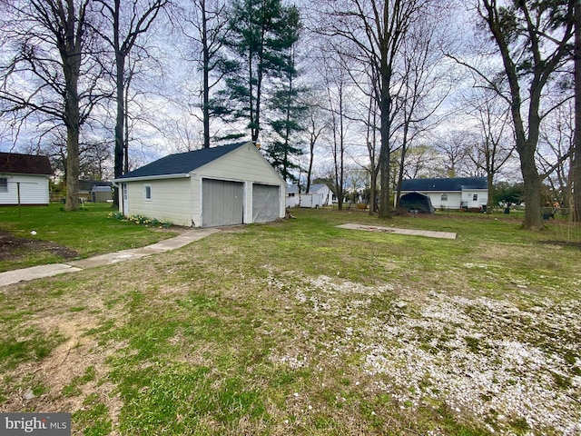 view of grassy yard with a garage and an outdoor structure