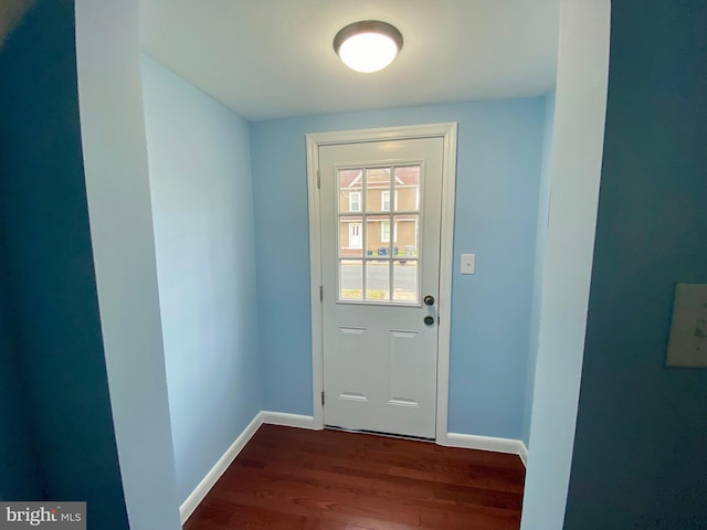 doorway to outside featuring wood finished floors and baseboards