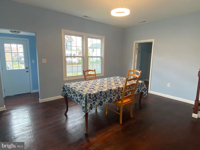 dining area with baseboards and dark wood-style flooring