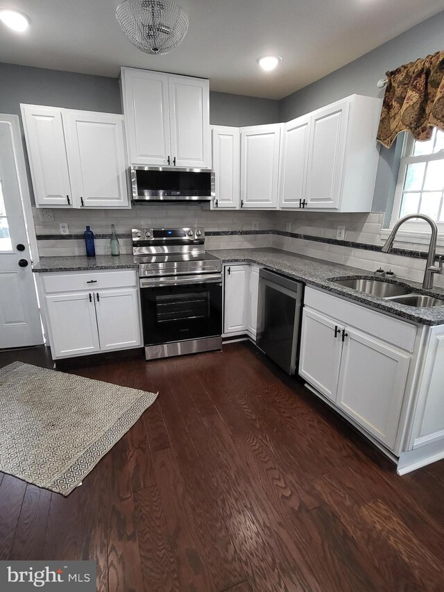 1211 Williamsville Rd, Houston, DE 19954 - kitchen featuring stainless steel appliances, a sink, dark stone countertops, white cabinets, and tasteful backsplash
