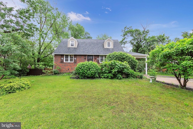 cape cod house with brick siding, a front lawn, and roof with shingles