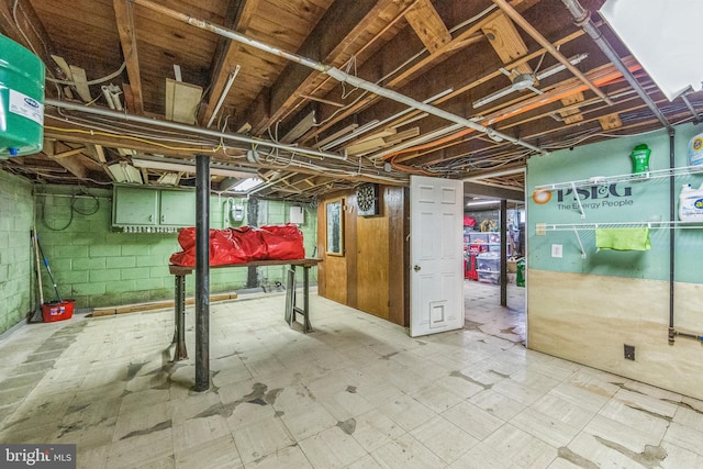 unfinished below grade area featuring tile patterned floors and concrete block wall