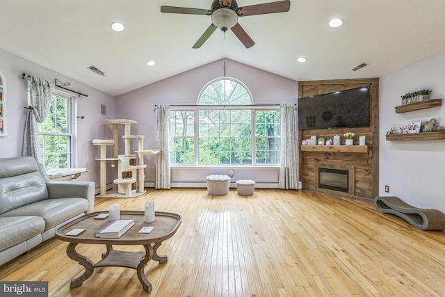 living area with vaulted ceiling, a large fireplace, a ceiling fan, hardwood / wood-style floors, and recessed lighting