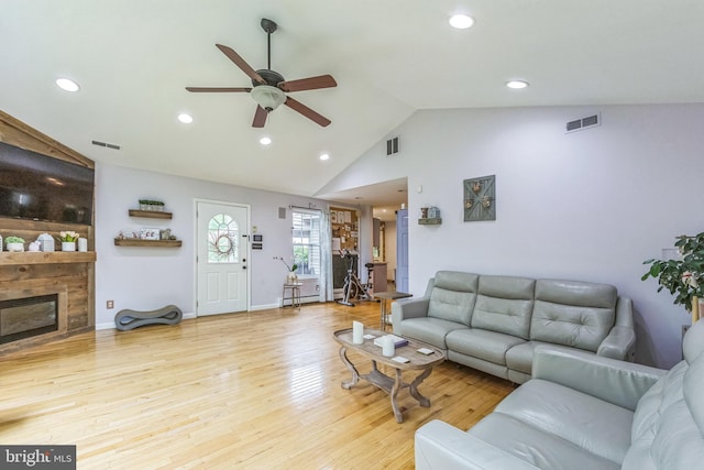 living area featuring a ceiling fan, recessed lighting, wood finished floors, a glass covered fireplace, and baseboards