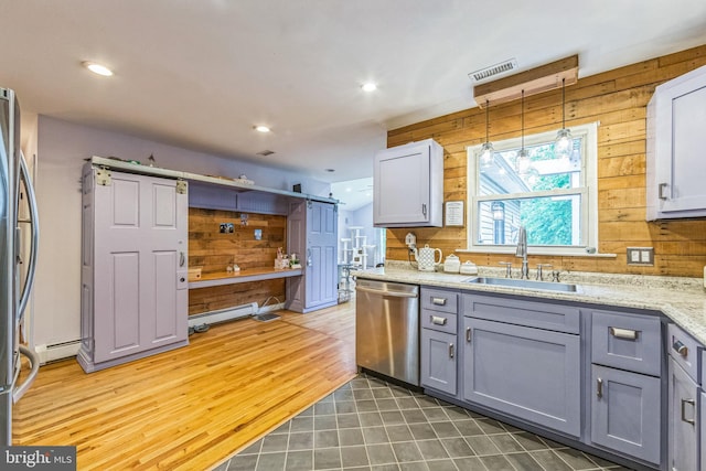 kitchen with stainless steel appliances, a sink, gray cabinets, wooden walls, and baseboard heating