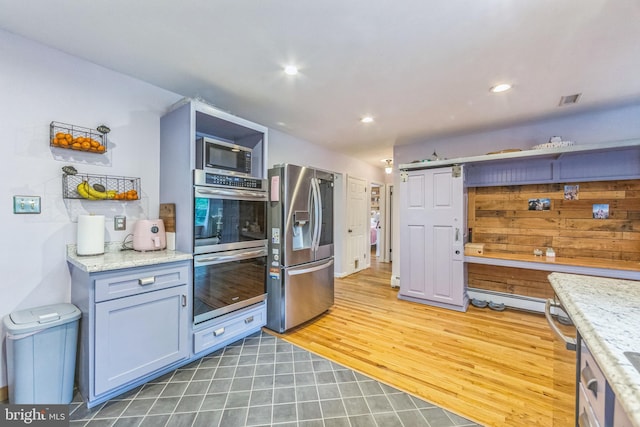 kitchen with stainless steel appliances, recessed lighting, light tile patterned floors, and light stone countertops