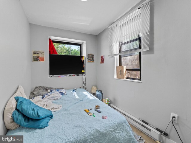 4951 W Thompson St, Philadelphia, PA 19131 - bedroom with baseboard heating, wood finished floors, and baseboards