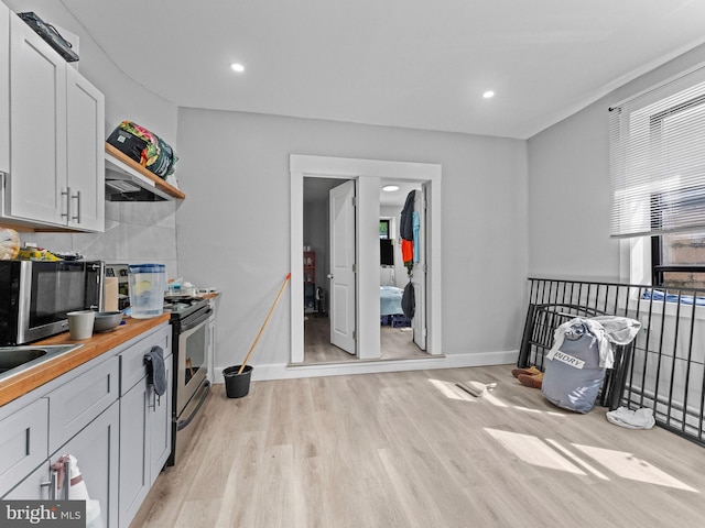 4951 W Thompson St, Philadelphia, PA 19131 - kitchen with stainless steel appliances, light wood-style floors, baseboards, open shelves, and backsplash
