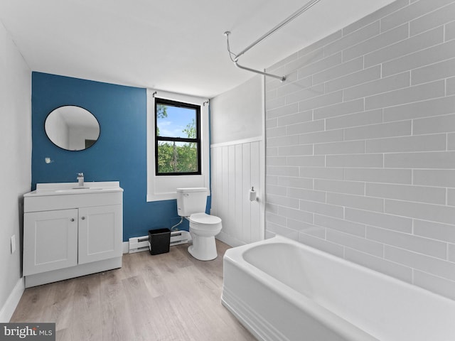4951 W Thompson St, Philadelphia, PA 19131 - bathroom with toilet, a baseboard heating unit, wood finished floors, vanity, and a wainscoted wall