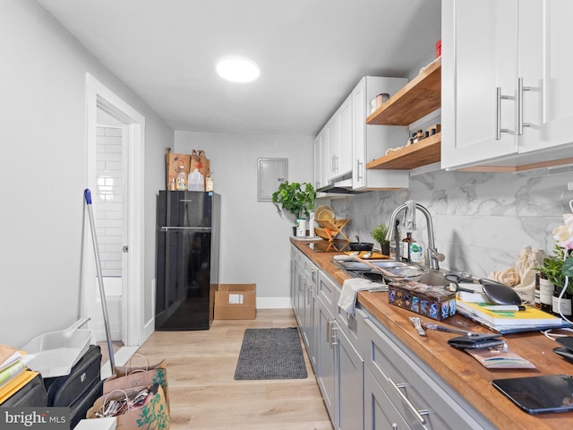 4951 W Thompson St, Philadelphia, PA 19131 - kitchen featuring freestanding refrigerator, open shelves, wood counters, light wood-type flooring, and decorative backsplash