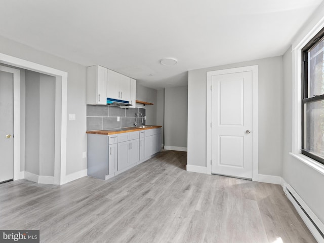 4951 W Thompson St, Philadelphia, PA 19131 - kitchen with a baseboard radiator, butcher block counters, a sink, and light wood finished floors