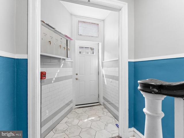 4951 W Thompson St, Philadelphia, PA 19131 - doorway to outside with wainscoting, light tile patterned floors, and tile walls