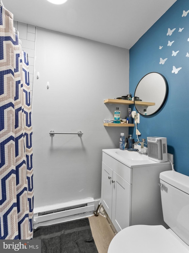 4951 W Thompson St, Philadelphia, PA 19131 - full bathroom with baseboard heating, toilet, wood finished floors, vanity, and a shower with curtain