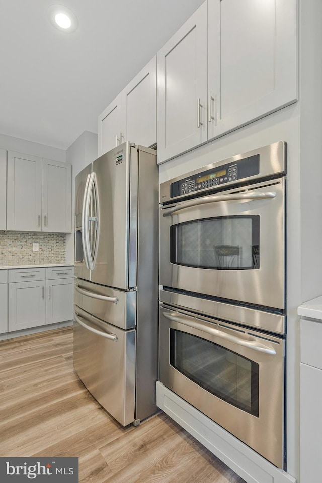 9310 Saffron Hill Ct, Manassas, VA 20110 - kitchen featuring stainless steel appliances, light wood-style floors, light countertops, tasteful backsplash, and recessed lighting