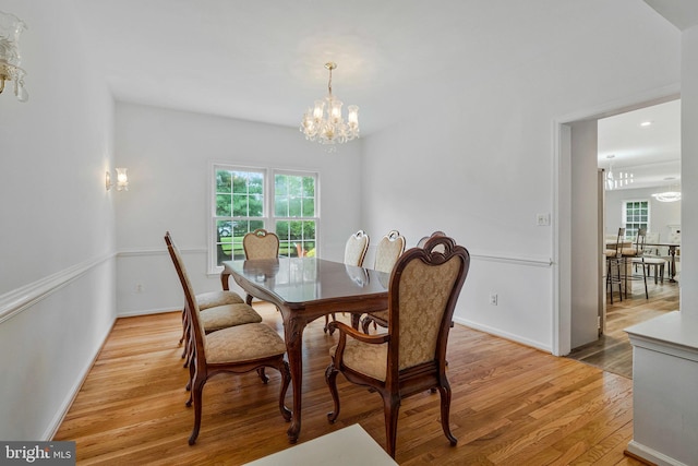 9310 Saffron Hill Ct, Manassas, VA 20110 - dining area with a chandelier, light wood finished floors, and baseboards
