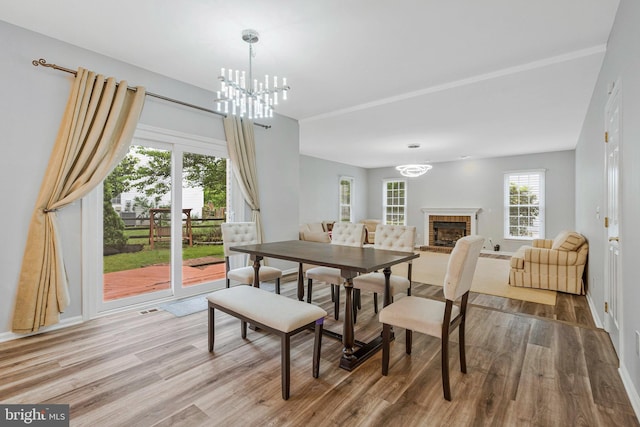 9310 Saffron Hill Ct, Manassas, VA 20110 - dining area featuring a chandelier, wood finished floors, and a fireplace