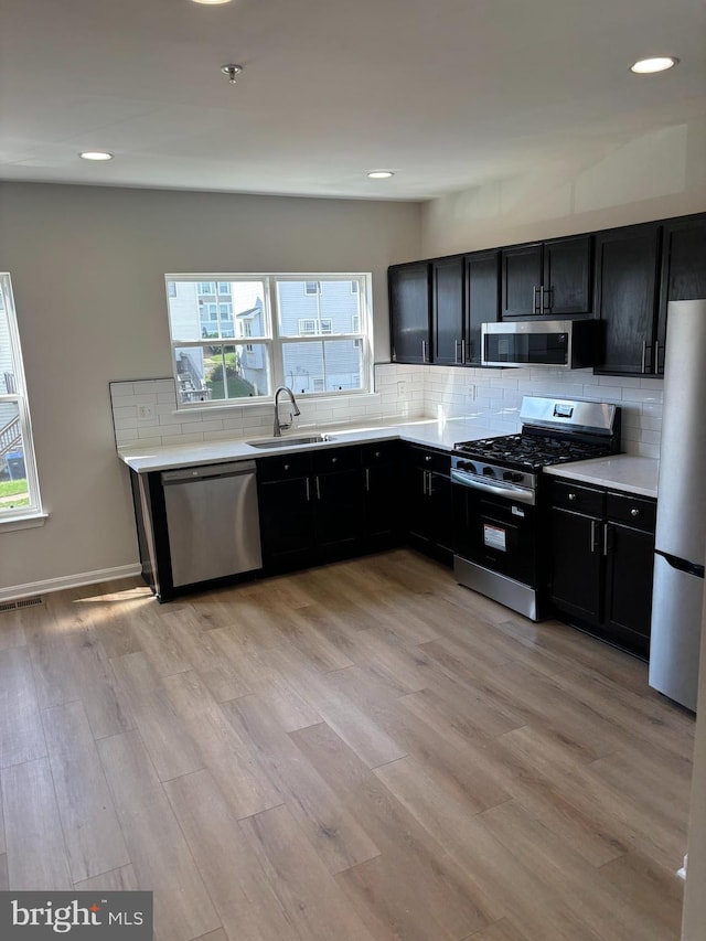 1853TOBIASDRIVESE Tobias Dr SE, Washington, DC 20020 - kitchen with stainless steel appliances, a sink, dark cabinetry, decorative backsplash, and plenty of natural light