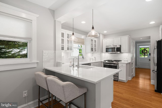 328 Avondale Ave, Haddonfield, NJ 08033 - kitchen featuring stainless steel appliances, a sink, a peninsula, decorative backsplash, and white cabinetry