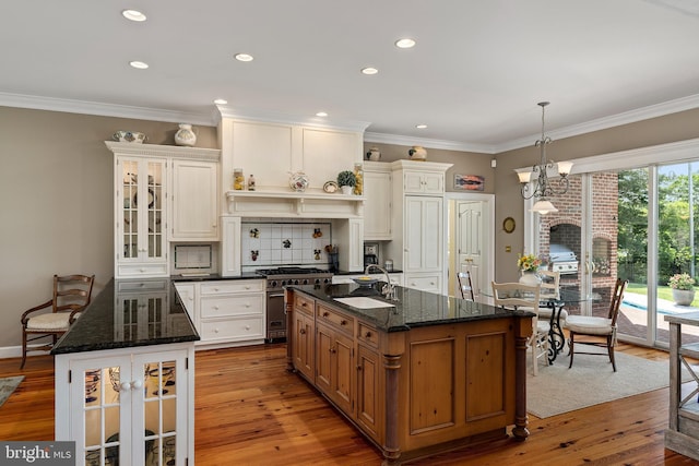 125 Oyster Pt, White Stone, VA 22578 - kitchen featuring a kitchen island with sink, high end stainless steel range oven, a sink, backsplash, and glass insert cabinets