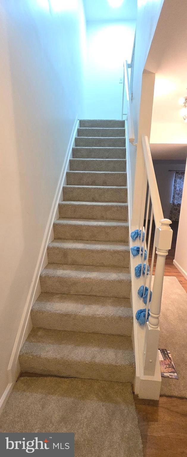 6924 Woodstream Ln, Lanham, MD 20706 - staircase featuring wood finished floors and baseboards