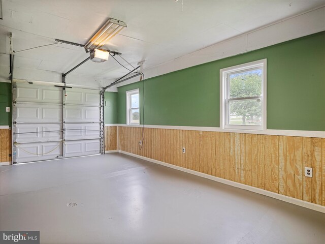 13914 Greencastle Pike, Hagerstown, MD 21740 - garage featuring a garage door opener, wooden walls, and wainscoting
