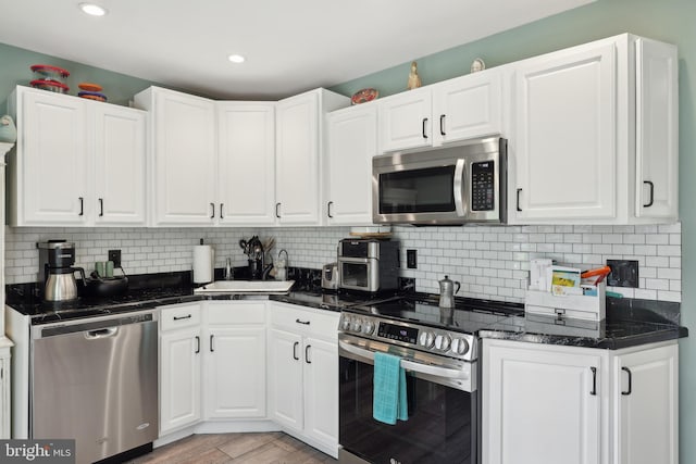 39 Village Ln, Levittown, PA 19054 - kitchen with appliances with stainless steel finishes, light wood-type flooring, white cabinetry, tasteful backsplash, and recessed lighting