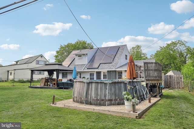 39 Village Ln, Levittown, PA 19054 - back of house with a gazebo, an outdoor pool, and solar panels