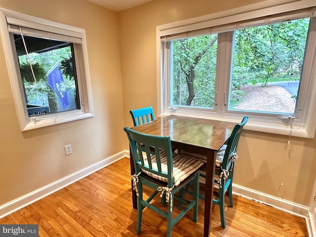 dining room with baseboards and light wood-type flooring