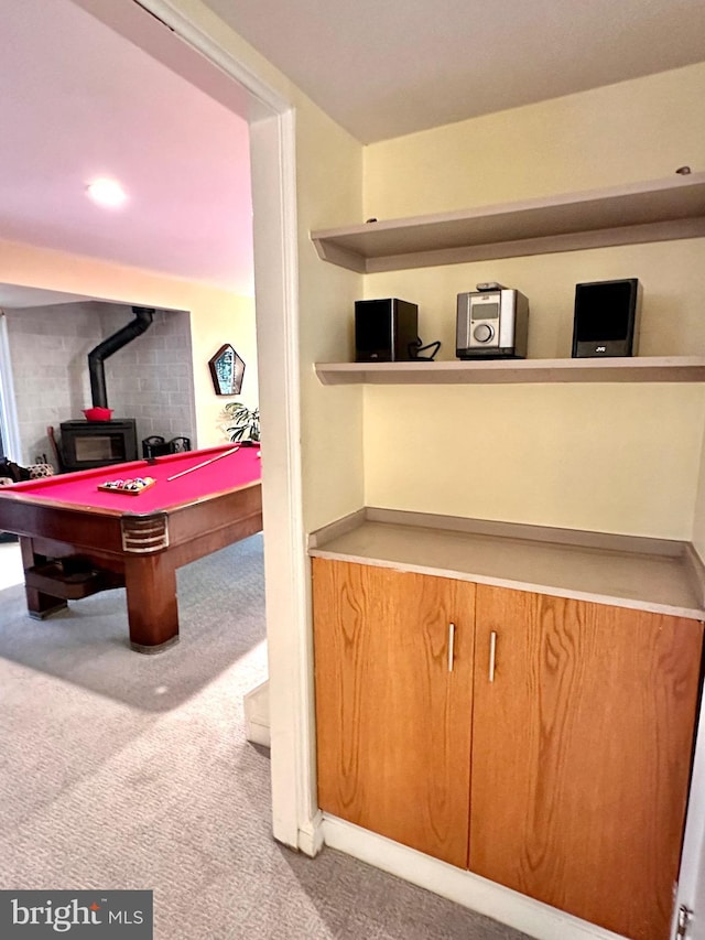 game room with carpet flooring, a wood stove, and billiards table