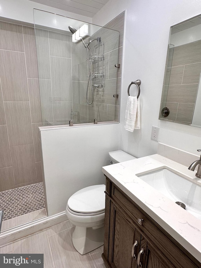 bathroom featuring a walk in shower, vanity, and toilet