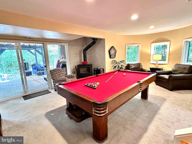 recreation room featuring carpet floors, a wood stove, plenty of natural light, and recessed lighting