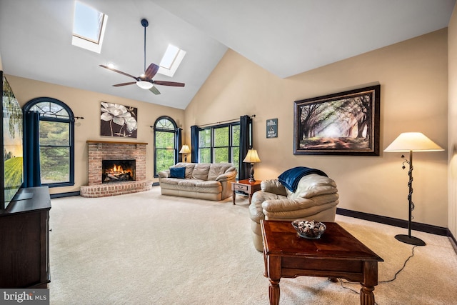 5 Craig Ln, Malvern, PA 19355 - carpeted living room featuring a skylight, high vaulted ceiling, a brick fireplace, ceiling fan, and baseboards