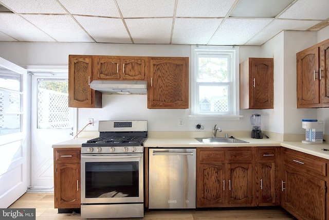 2530 18th St N, Arlington, VA 22201 - kitchen with appliances with stainless steel finishes, under cabinet range hood, a sink, a drop ceiling, and healthy amount of natural light