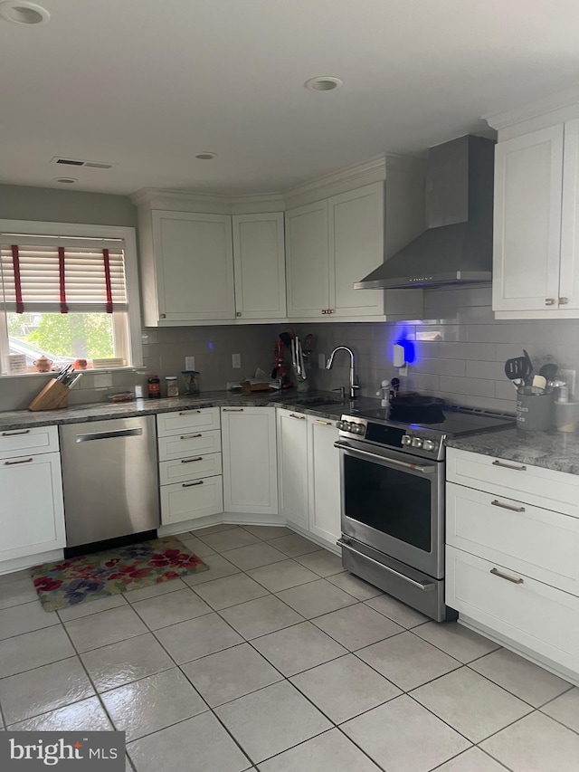 105 Bayview Ln, Hague, VA 22469 - kitchen featuring stainless steel appliances, wall chimney range hood, a sink, light tile patterned floors, and tasteful backsplash