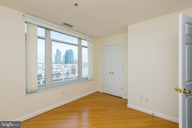 100 Harborview Dr Unit 513, Baltimore, MD 21230 - unfurnished bedroom featuring light wood-style flooring, baseboards, and multiple windows