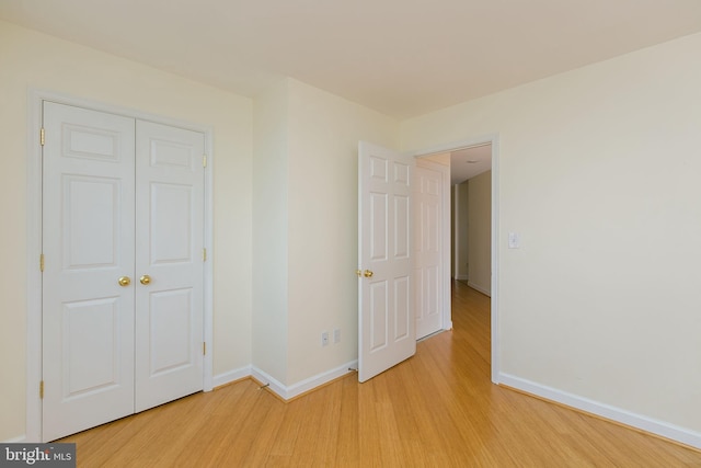 100 Harborview Dr Unit 513, Baltimore, MD 21230 - unfurnished bedroom featuring light wood-style floors, baseboards, and a closet