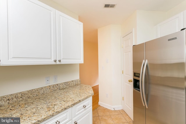 100 Harborview Dr Unit 513, Baltimore, MD 21230 - kitchen with stainless steel fridge with ice dispenser, white cabinetry, and light tile patterned flooring