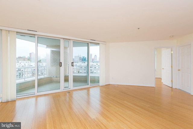 100 Harborview Dr Unit 513, Baltimore, MD 21230 - spare room featuring light wood-type flooring, a city view, and baseboards