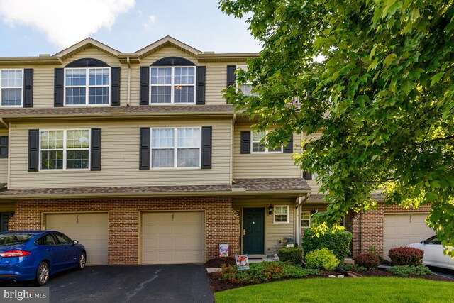261 Osprey Ln, Hummelstown, PA 17036 - townhome / multi-family property with driveway, an attached garage, and brick siding