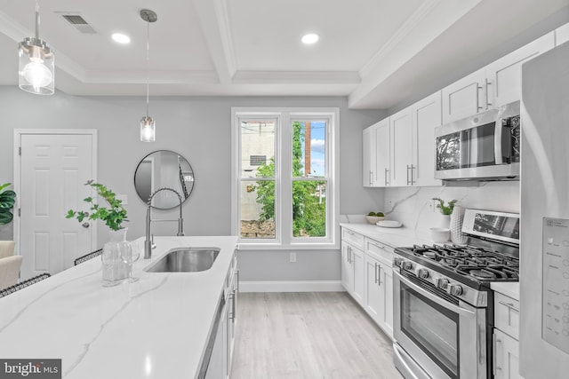 1505 N Pulaski St, Baltimore, MD 21217 - kitchen with appliances with stainless steel finishes, crown molding, a sink, white cabinets, and light wood finished floors