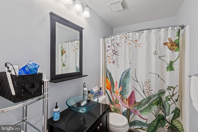 full bath featuring toilet, vanity, and a shower with shower curtain