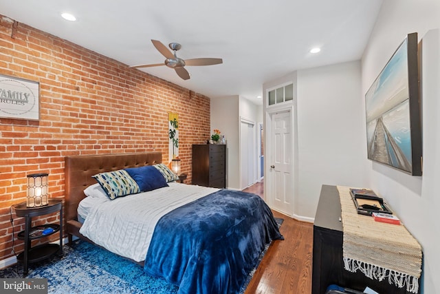 bedroom featuring brick wall, wood finished floors, recessed lighting, a closet, and ceiling fan