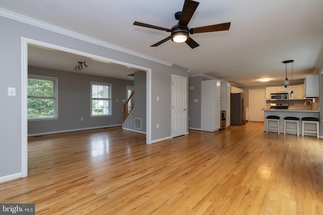 306 Canyon Rd, Winchester, VA 22602 - unfurnished living room with crown molding, light wood-style floors, stairs, a sink, and ceiling fan