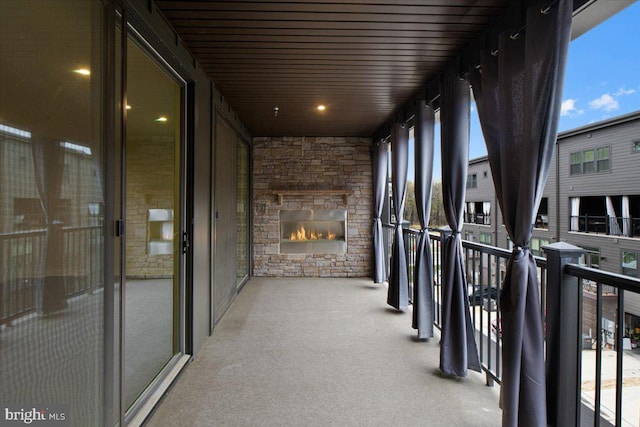 balcony with an outdoor stone fireplace
