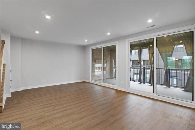 unfurnished room with wood finished floors, baseboards, and recessed lighting