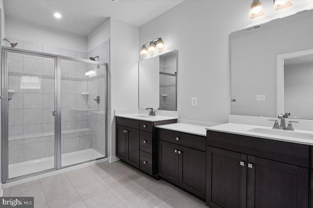 full bathroom with a stall shower, two vanities, and tile patterned flooring