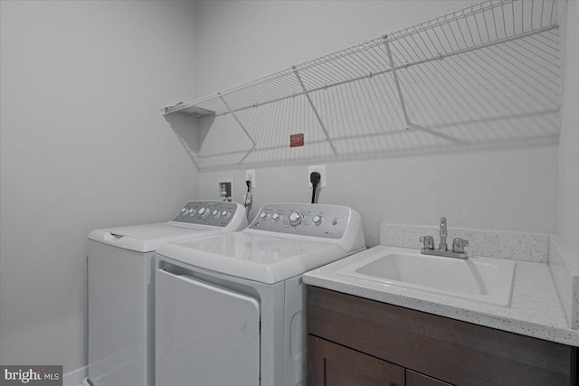 laundry room with washer and dryer and a sink