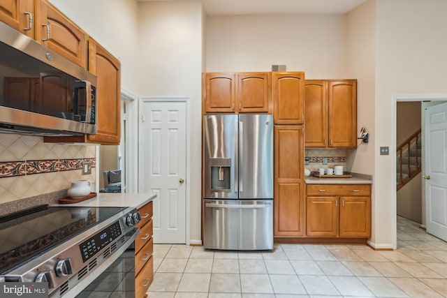 2032 Franklin Cluster Ct, Falls Church, VA 22043 - kitchen featuring stainless steel appliances, a high ceiling, light tile patterned floors, tasteful backsplash, and light countertops